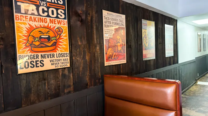 Wood wall with framed posters next to a booth